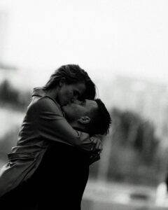 couple kissing while man hold woman in the air